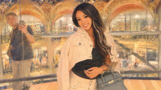パリの百貨店で撮られた一枚を思わせるイラスト。奥のガラスに撮影者が映り込んでいる